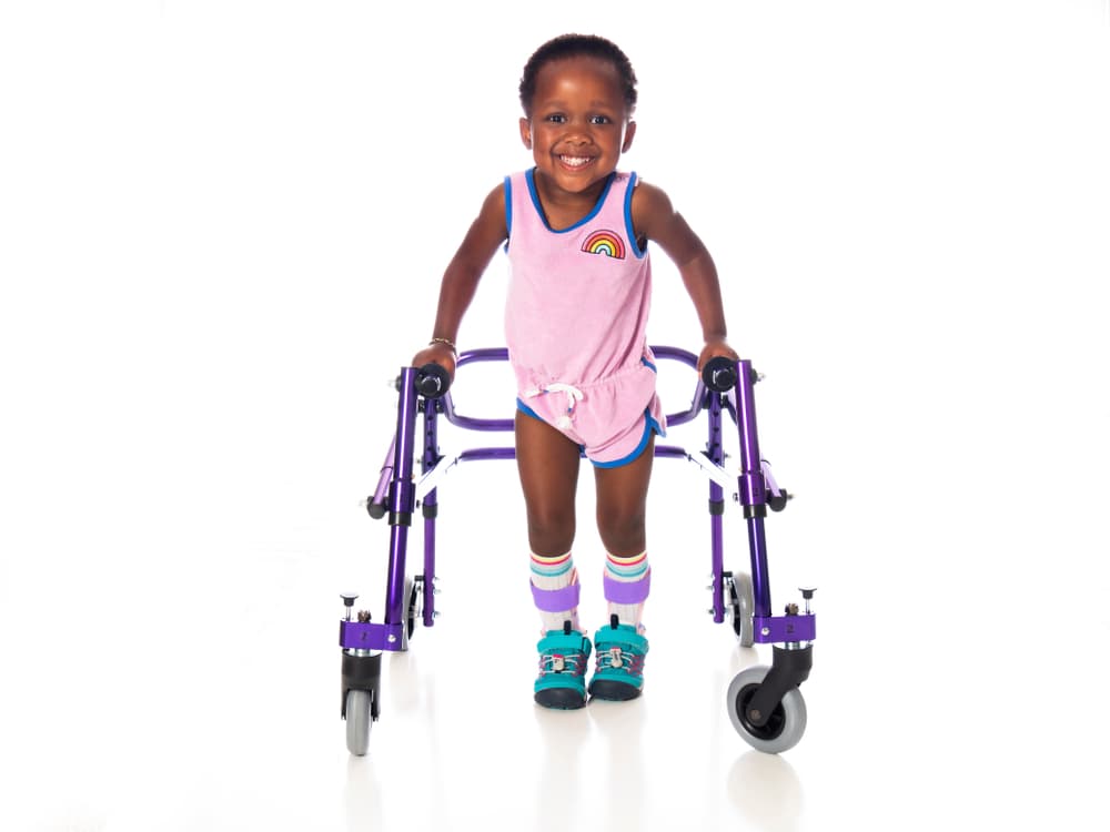 Figura 4 – Criança com paralisia cerebral nível III do GMFCS, utilizando andador posterior e órteses nos tornozelos (suropodálicas).