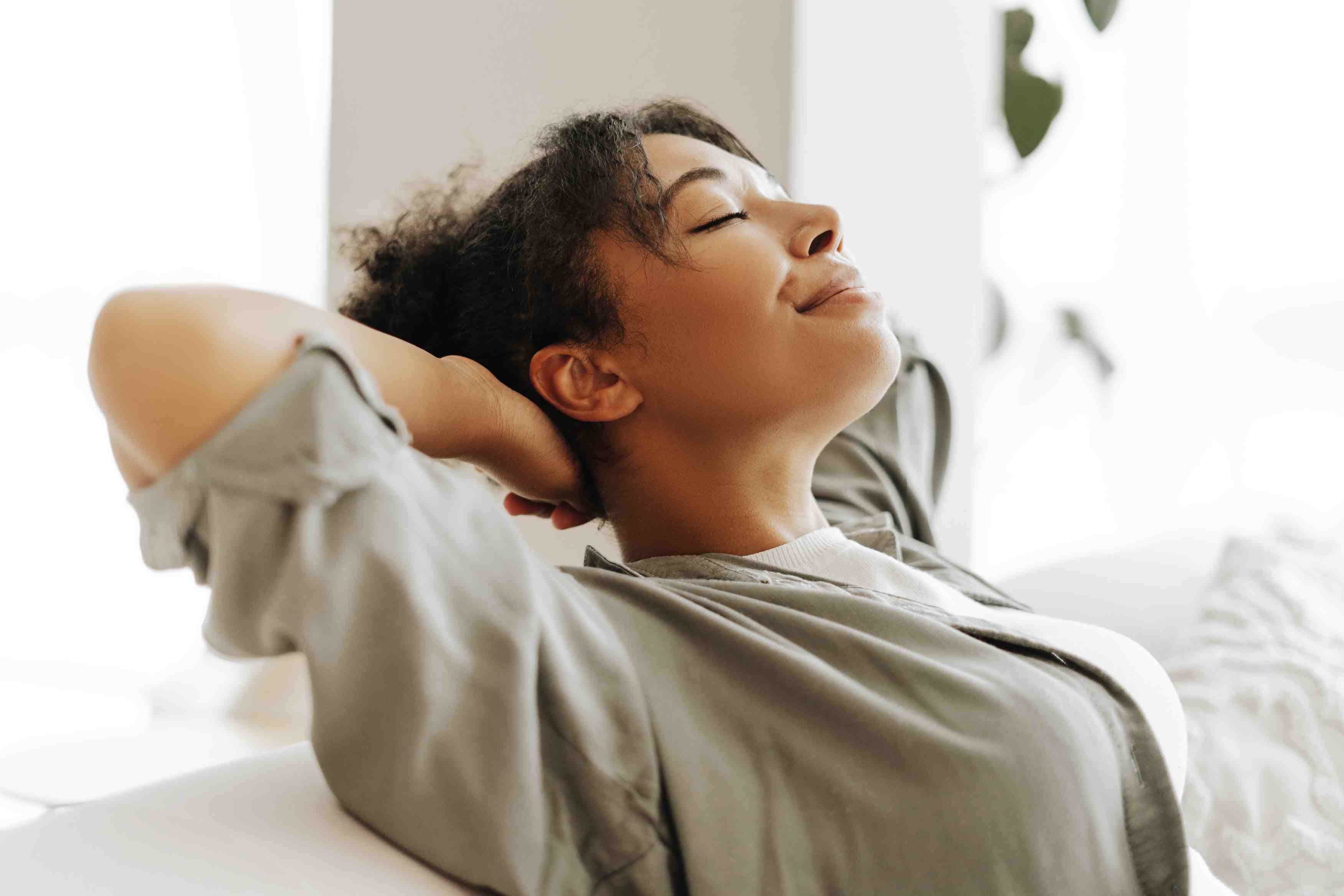 Mulher relaxando no sofá em momento de tranquilidade, autocuidado e bem-estar emocional