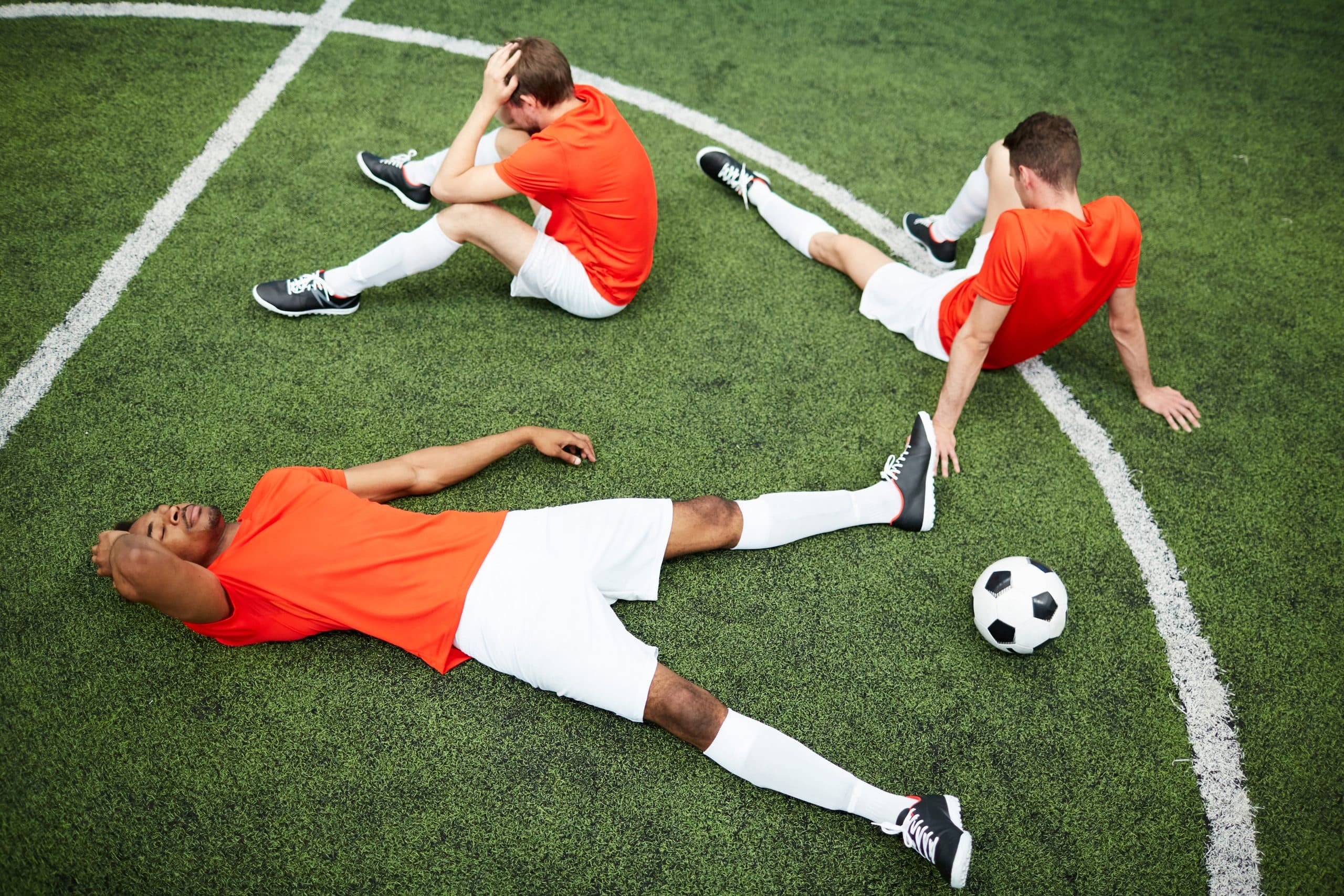 Jogadores de futebol frustrados, cansados em campo
