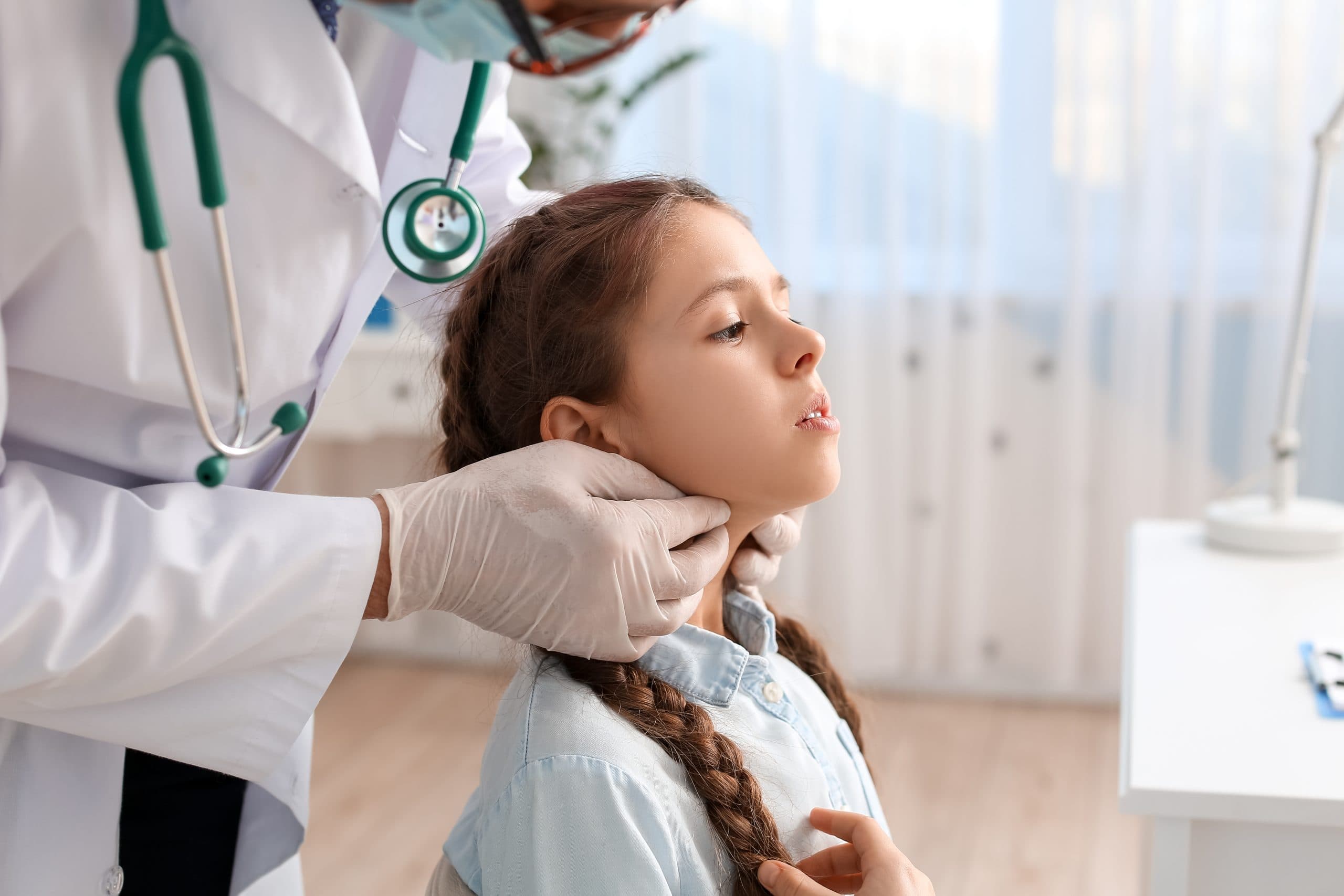 Doctor,Examining,Little,Girl's,Neck,In,Clinic