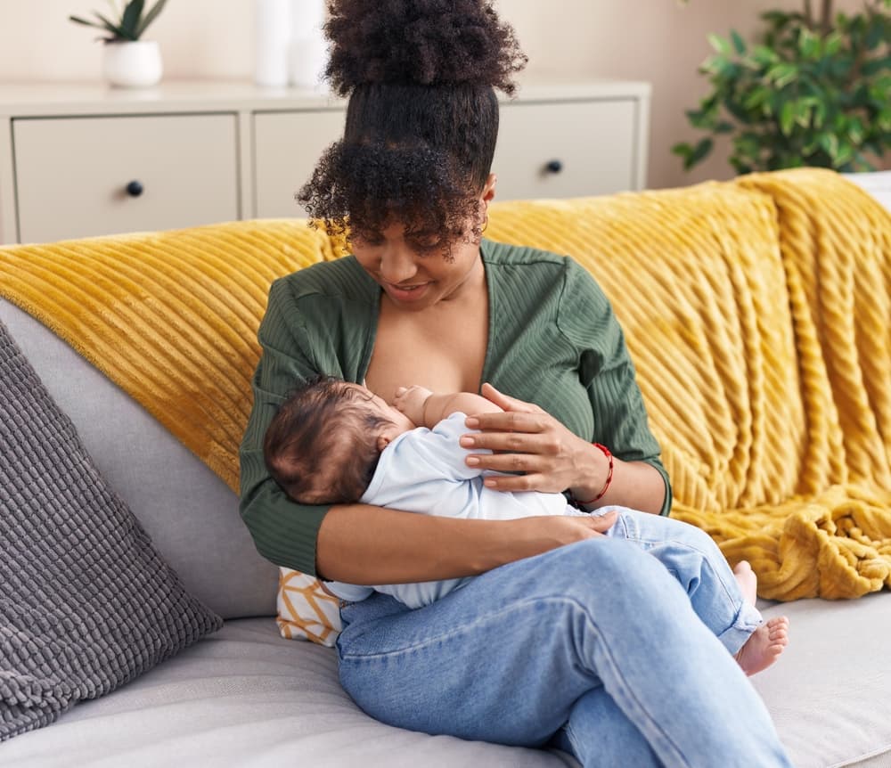Mother,And,Son,Sitting,On,Sofa,Breastfeeding,At,Home