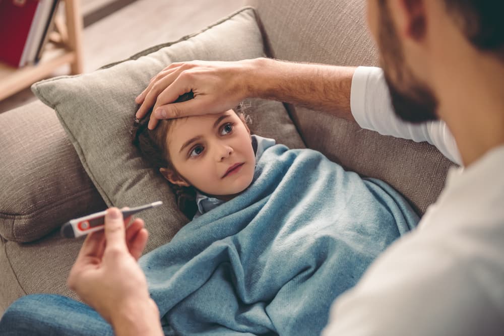 Sick,Little,Girl,Covered,In,Blanket,Is,Lying,On,Couch