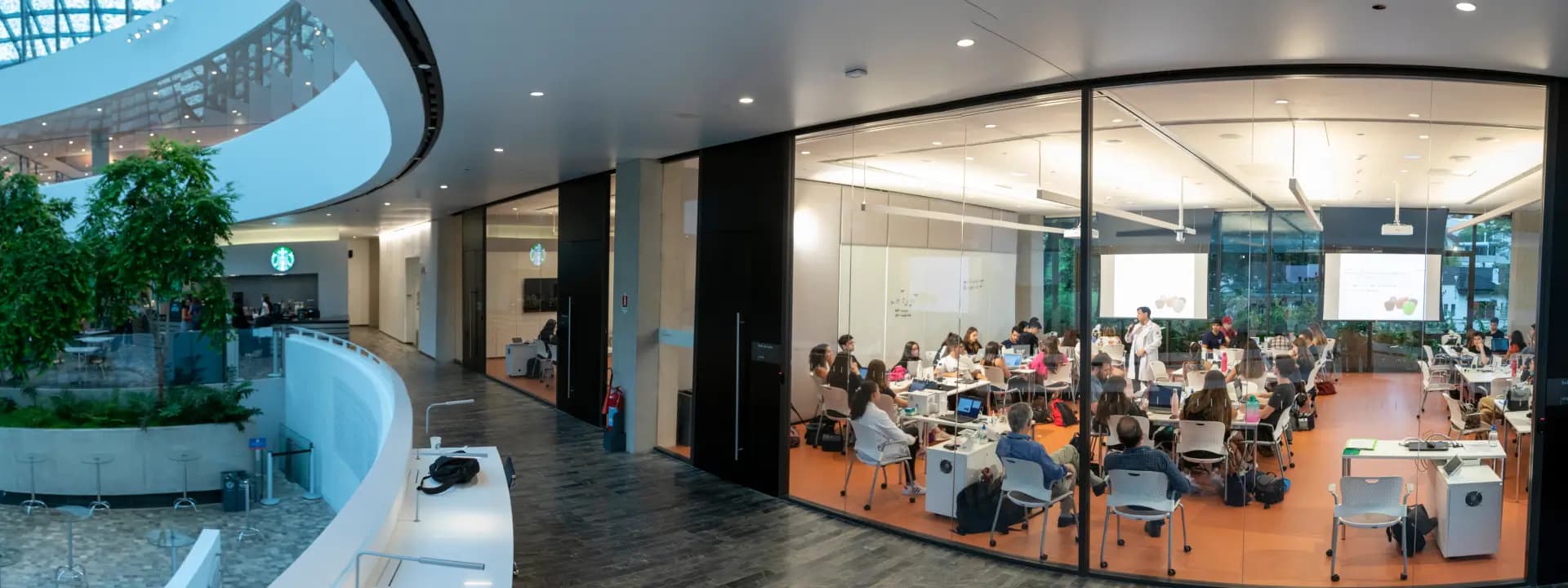 Ambiente moderno no Einstein com pessoas em sala de aula envidraçada, destaca a estrutura de excelência para ensino e formação, promovendo educação de alta qualidade na área da saúde