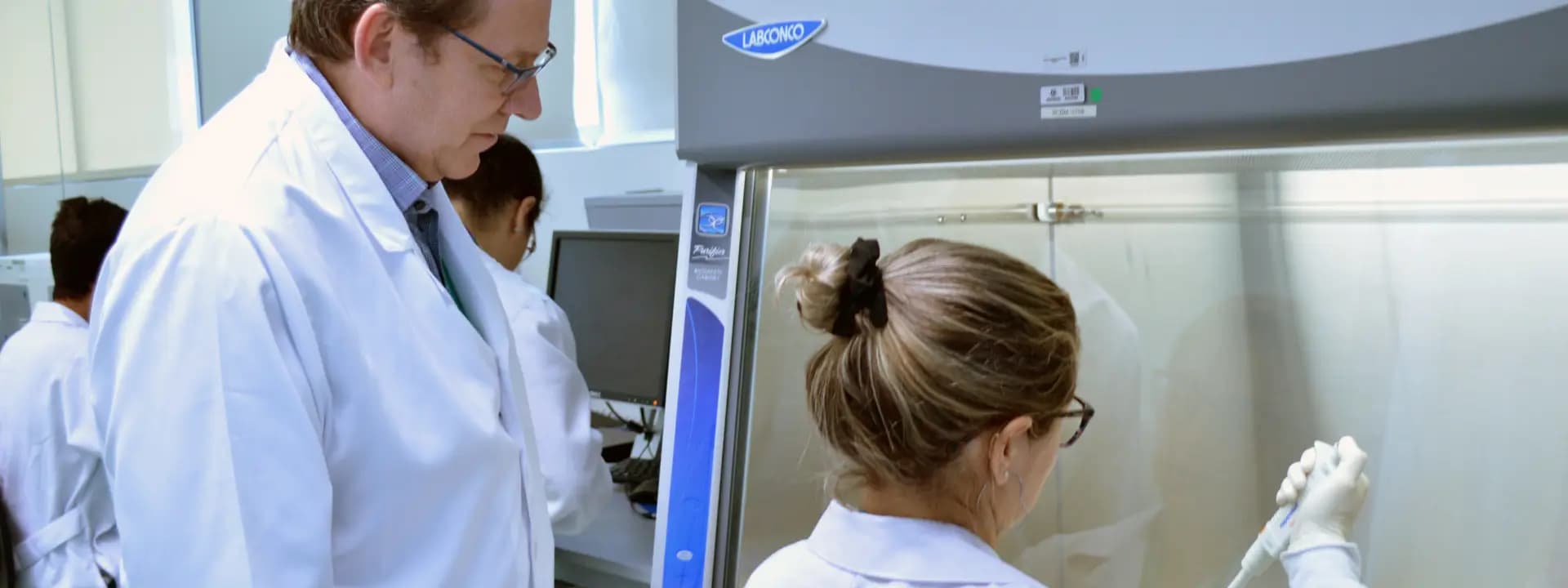 Cientistas trabalhando em laboratório no Einstein, representa momentos históricos e pessoas que marcaram a memória da instituição com contribuições para a inovação e excelência na área da saúde