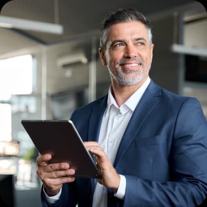 Homem em traje executivo segura um tablet em ambiente corporativo, representa oportunidades de desenvolvimento e sucesso em carreiras no Einstein, com foco em saúde e inovação.
