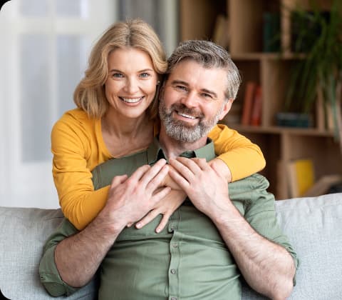 Casal sorridente abraçados no sofá, representa saúde e bem-estar, associados aos avanços no tratamento do câncer no sangue para diagnóstico e tratamento de doenças do sangue com precisão e cuidado especializado. Casal sorridente abraçados no sofá, representa saúde e bem-estar, associados aos avanços no tratamento do câncer no sangue para diagnóstico e tratamento de doenças do sangue com precisão e cuidado especializado.