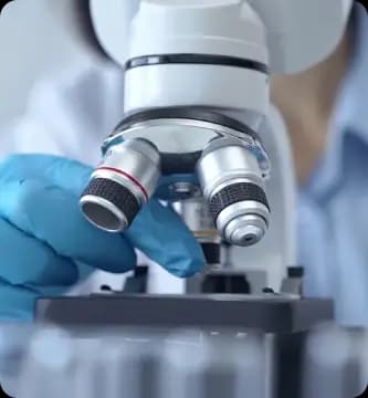 Cientista utiliza microscópio em laboratório, representa o compromisso do Einstein com a pesquisa científica, inovação e avanços na área da saúde para promover tratamentos e diagnósticos de excelência.