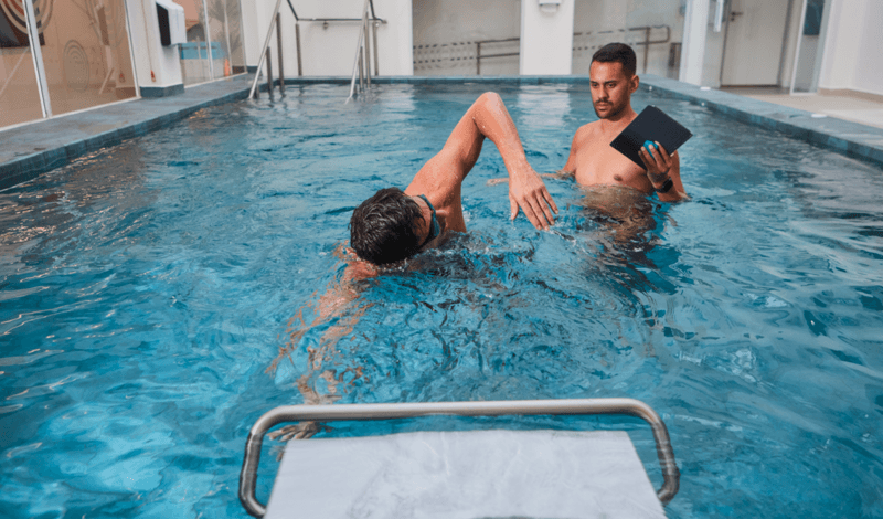 homem na piscina do Espaço Einstein realizando treino de nado com apoio de profissional especializado homem na piscina do Espaço Einstein realizando treino de nado com apoio de profissional especializado