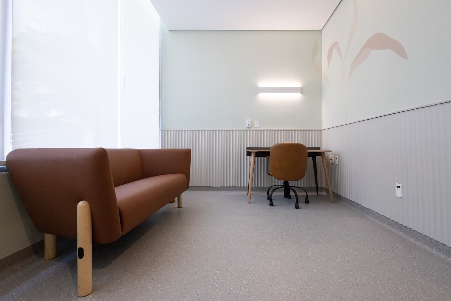Imagem de um consultório focado em Saúde Mental e Bem-estar com um sofá espaçoso e uma mesa ao lado. O espaço é versátil e pensado para proporcionar conforto e privacidade durante as consultas.