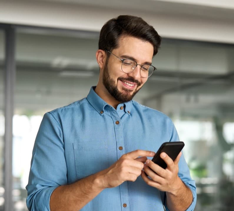 homem de camisa azul utilizando seu smartphone homem de camisa azul utilizando seu smartphone