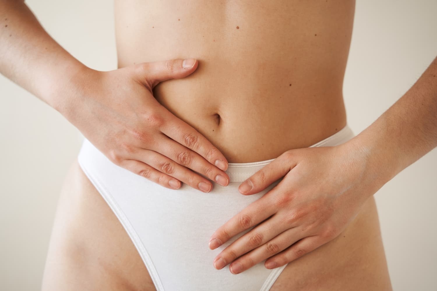 Uma pessoa com as mãos sobre a barriga, expressando a sensação de estar grávida.