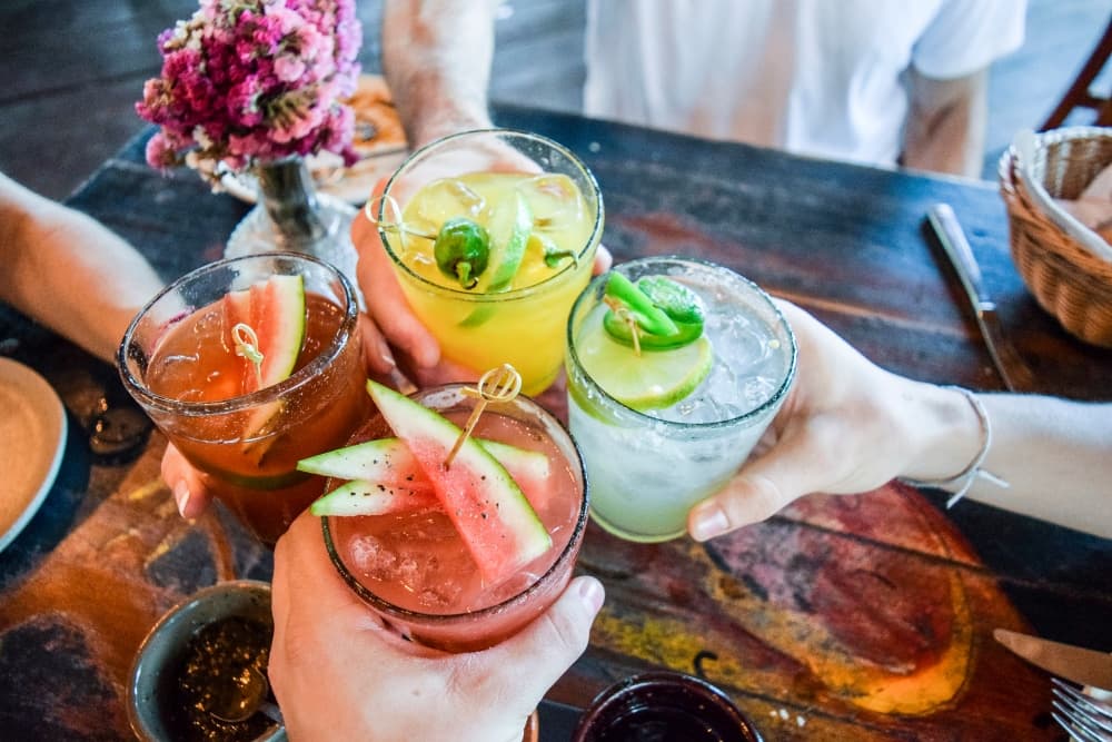 4 pessoas fazendo um brinde com bebidas alcoólicas
