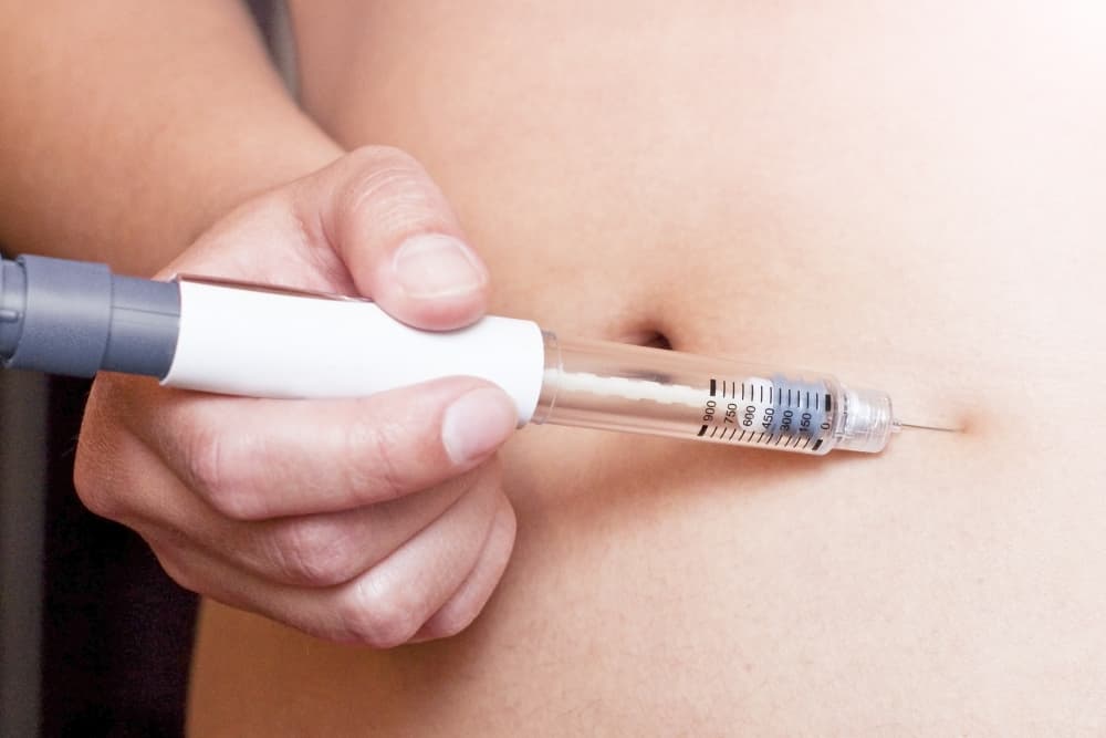 Uma pessoa fazendo aplicação na região do abdômen de medicamento para emagrecimento