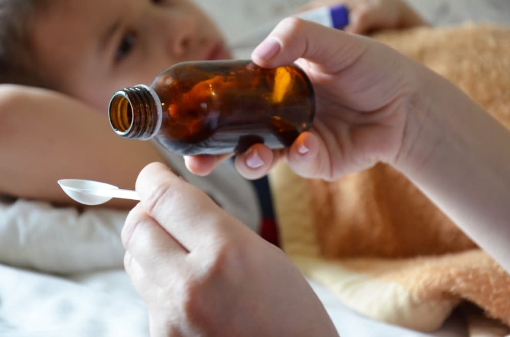 Uma criança recebendo uma dose do medicamento ambroxol para tratamento das vias aéreas