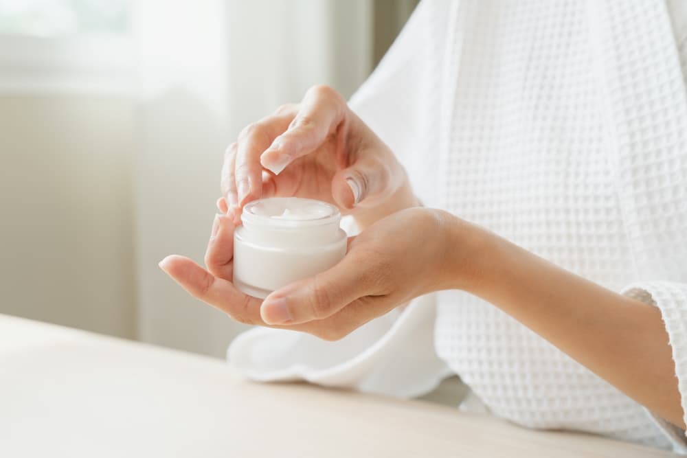 Uma pessoa com um frasco de ácido azelaico preparando a aplicação para a pele do rosto - tratamento de acne e rosácea