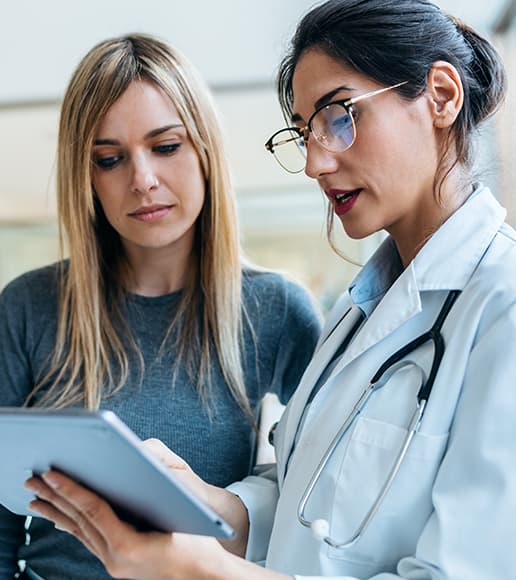 Profissional de saúde e paciente durante consulta e apresentação de informações em um tablet. Profissional de saúde e paciente durante consulta e apresentação de informações em um tablet.