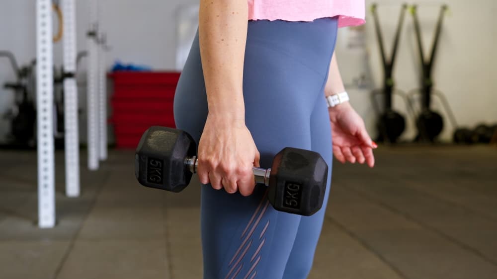 Uma pessoa na menopausa praticando exercícios com halteres