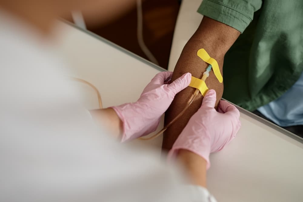 Profissional de saúde administrando o medicamento nivolumabe por via intravenosa durante uma sessão de imunoterapia.