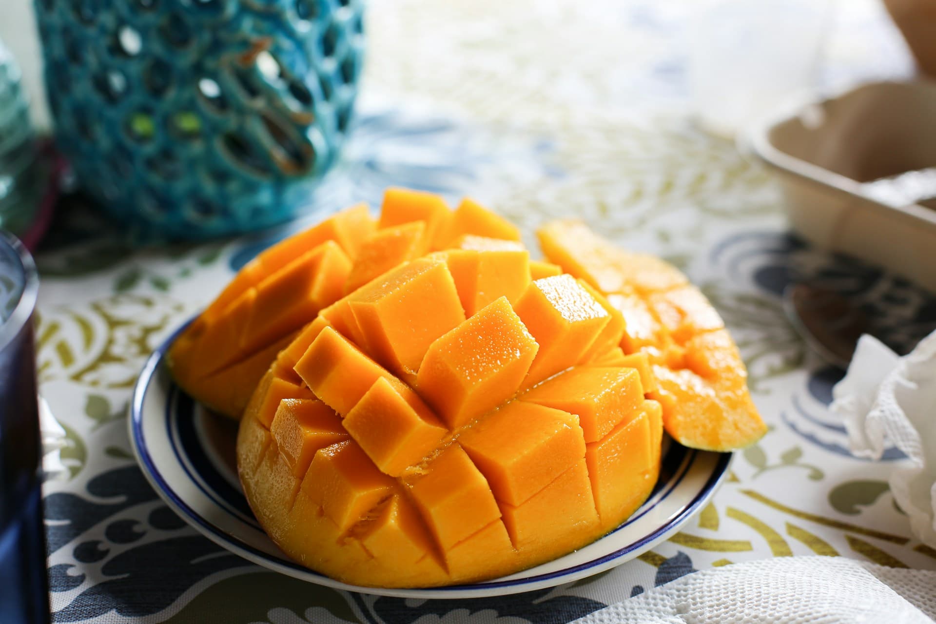 Sobre uma mesa, uma manga cortada e já sem o caroço.