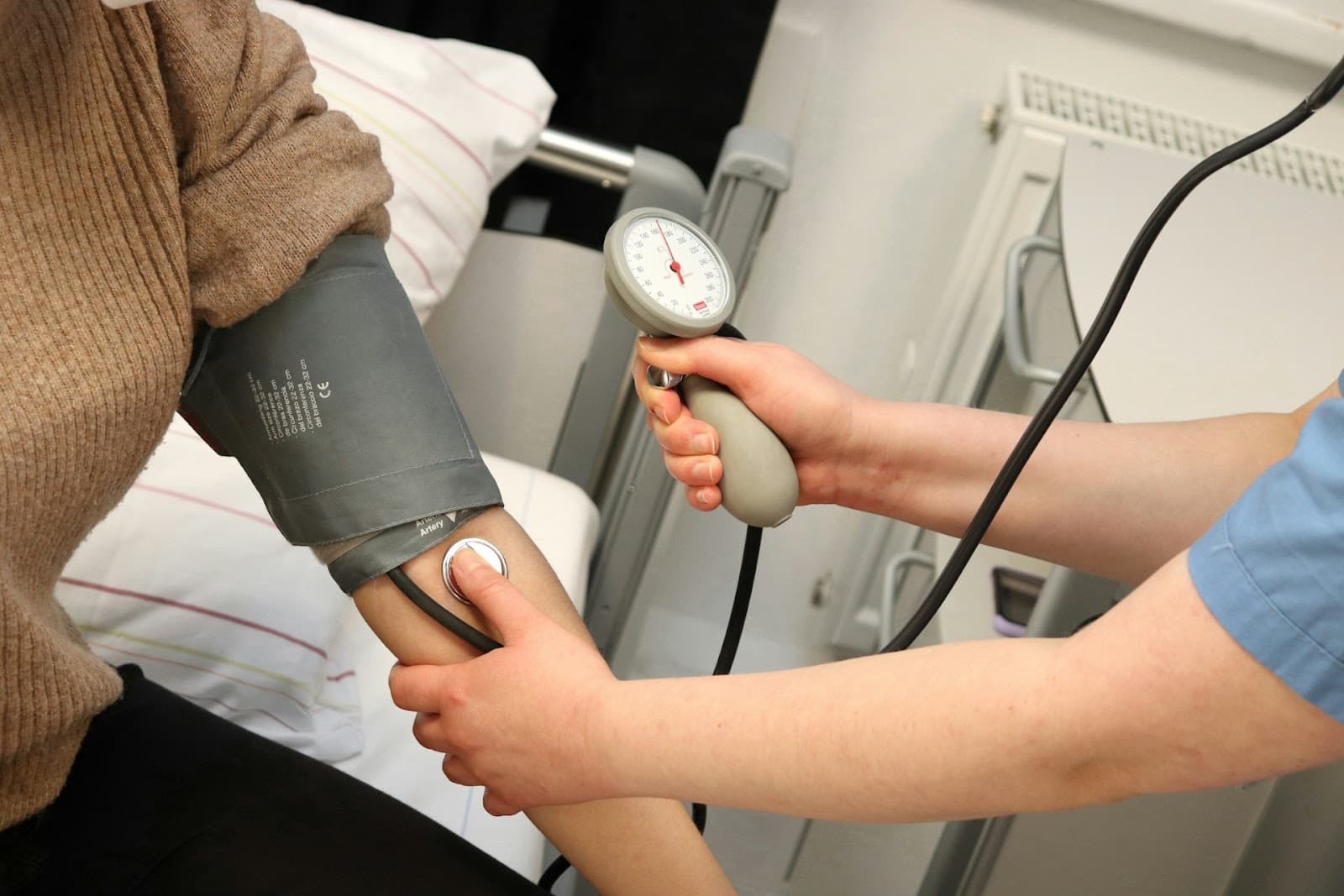 Um profissional de saúde aferindo a pressão de um paciente durante check-up anual