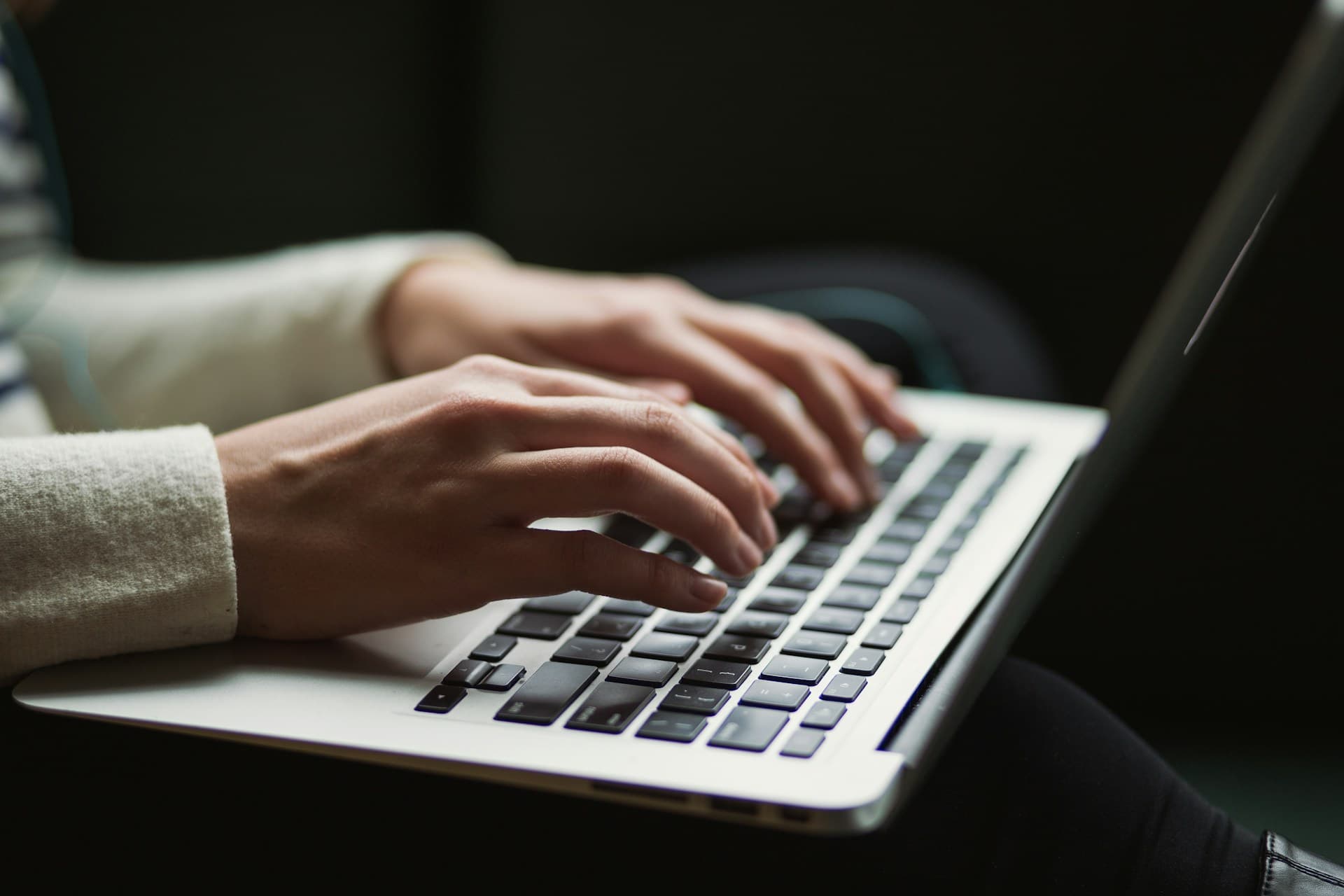 Pessoa com laptop no colo conectando-se com outras pessoas ao redor do mundo.