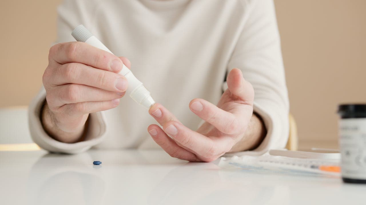 Pessoa fazendo exame de sangue para teste de glicemia.