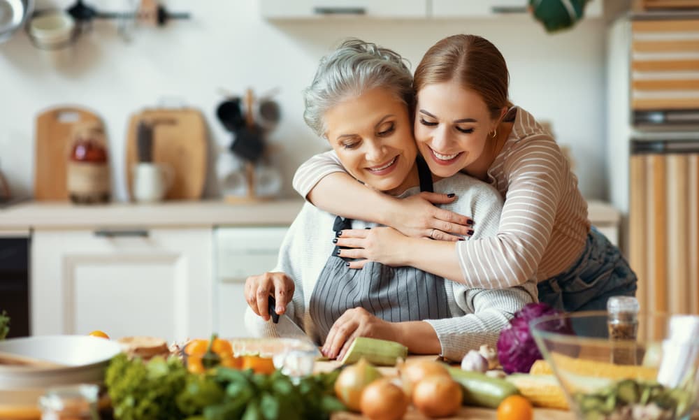 Happy,Family,Cheerful,Young,Woman,Embracing,Mature,Mother,While,Preparing