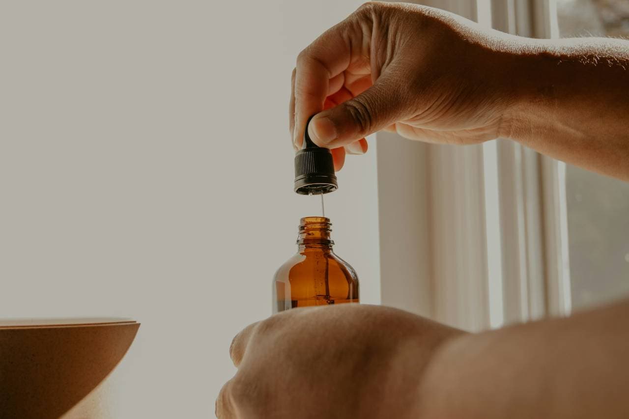 Pessoa dosando o medicamento com um conta gotas