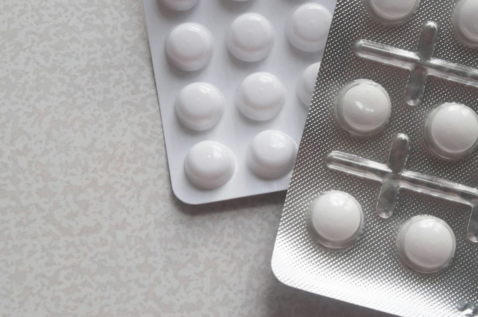 Cartelas de medicamentos diferentes sobre uma mesa.