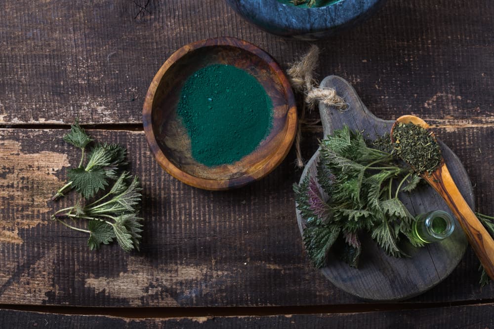 Fresh,Stinging,Nettle,Leaves,On,Wooden,Table.urtica,Dioica,Oil,With