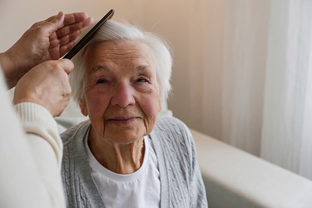 Unrecognizable,Female,Expressing,Care,Towards,An,Elderly,Lady,,Brushing,Her