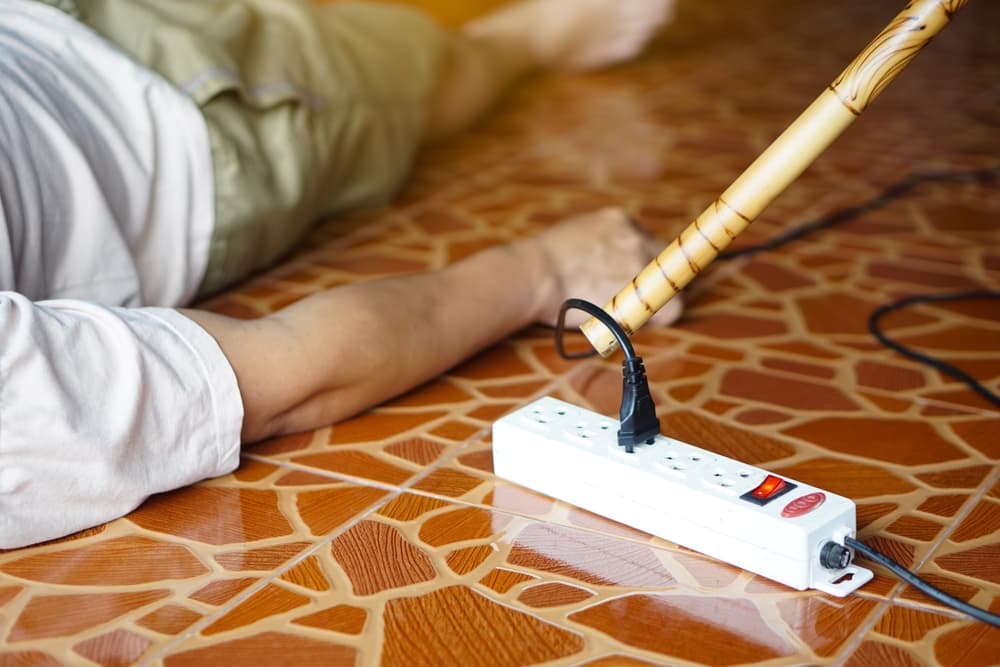 Using,Wooden,Stick,Is,Moving,Away,The,Electric,Plug,Socket