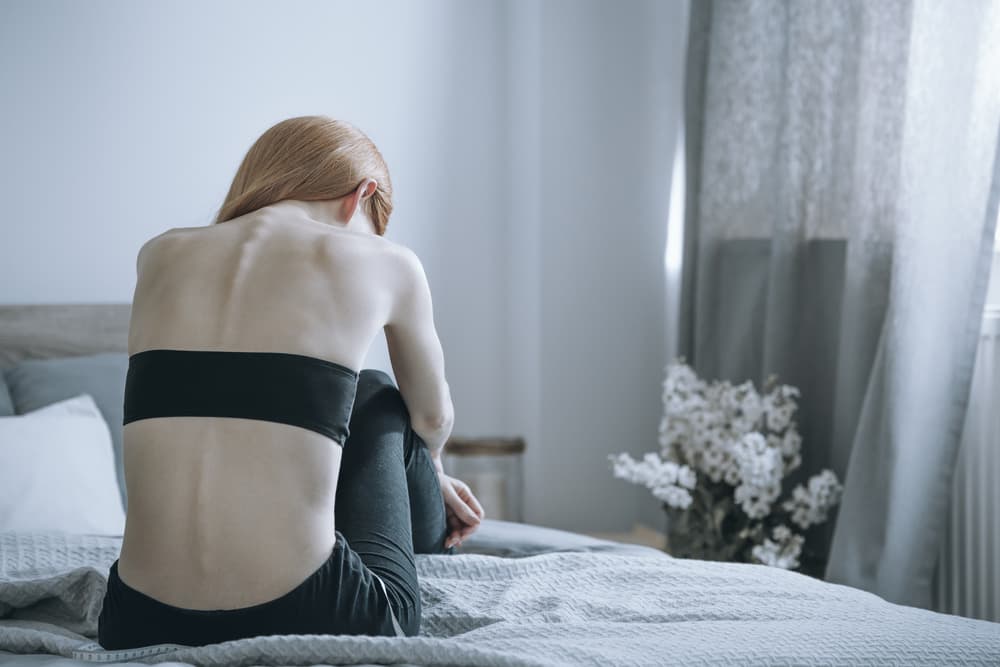 Young,Woman,With,Anorexia,Sitting,Alone,On,Bed,And,Feeling