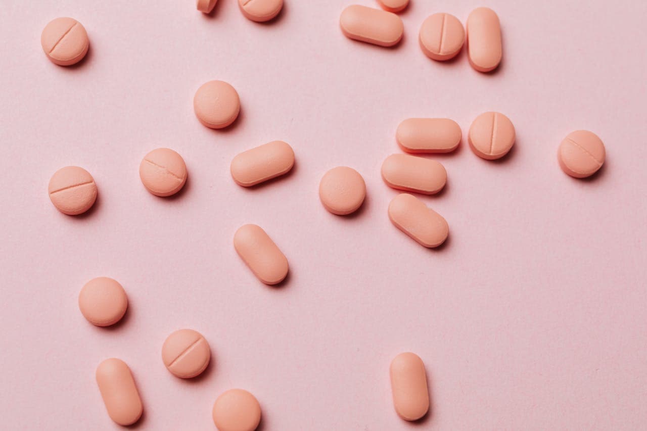 Medicamentos em comprimidos espalhados em superfície plana.