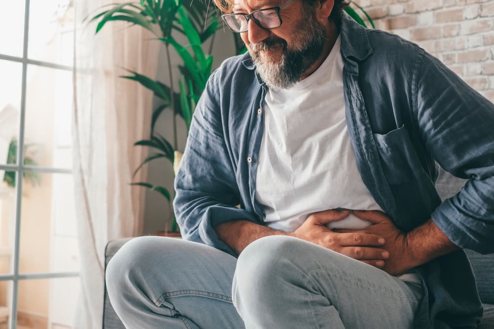 Homem com dor na região do abdômen